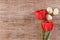 Holiday background with red tulips and Easter Eggs on light brown background Text space top view