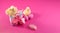 Holiday banner with Bright yellow chickens with easter eggs and gift box on a pink color background. Trendy hard light still life