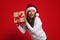 Holiday Bonus. Excited Young Woman Wearing Santa Hat Holding Wrapped Gift Box