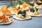 Holiday canapes with red and black caviar, on crackers festive silver Christmas decoration, copy space, selected focus, narrow