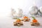 Holiday canapes from toasted bread in star shape, cream and red caviar with dill garnish on a light wooden table with candles and