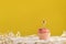 Holiday card with cupcake with candles on bright yellow background and place for your text