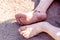 Holiday concept of dirty child feet on dirty soil