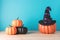 Holiday concept with Halloween pumpkin decor and witch hat on wooden table. Creative Halloween minimal concept