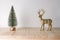 Holiday concept with reindeer and Christmas tree on wooden table. Creative Christmas or New Year background