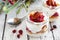 Holiday cranberry granola parfaits in mason jars against white wood