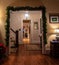 Holiday decorated archway as entrance to staircase and door to kitchen