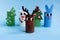 Holiday easy DIY craft idea for kids. Toilet paper roll tube toy Christmas tree, snowman, rabbit, deer on blue