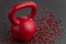 Holiday fitness, red kettlebell, with red heart confetti, on a black gym floor