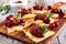 Holiday flatbread appetizers with cranberries and brie, close up on a wood platter