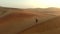 Holiday, freedom and man walking in the desert, dunes and travel adventure in Morocco. Sand, hill and person walking in