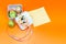 A holiday gift with a note for congratulations. Gift packaging with sweets. Orange background. Selective focus