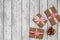 Holiday gifts wrapped in brown paper and holly on a white wooden background. New Year and Christmas concept. Flat lay