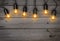 Holiday glowing garland of light bulbs on vintage wooden background