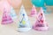 Holiday hats  and decor on pink and blue background. Twins birthday. Pink and blue paper hats for girls and boys