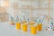 Holiday hats and paper cups with beverage and straws on white table. Festive event. Birthday party celebration concept. Blurred