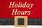 Holiday Hours message on red and black Santa suit