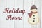 Holiday hours sign with snowman