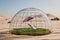 Holiday idyll with sun lounger and parasol on a small grassy area under a glass dome in the middle of the desert Air conditioning