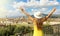 Holiday in Italy. Panoramic back view of young woman with hat and raised arms looking at Florence city, Tuscany, Italy