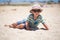 Holiday, little boy three years old fun digging in the sand at the beach