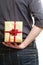 Holiday. Man hiding surprise gift box behind back