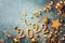 Holiday New year background with golden Christmas decorations and 2022 numbers and confetti stars on blue top view