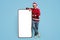 Holiday Offer. Cheerful Man In Santa Hat Standing Near Big Blank Smartphone