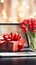 Holiday online shopping concept. Blank notebook, bouquet of tulip flowers and festive gifts box