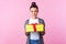 Holiday present. Portrait of positive teenage brunette girl holding gift box and smiling. pink background