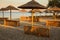 Holiday resort with a beach and sea view with sunshades at sunset
