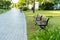 Holiday resort with bench, green trees, grass and early sunlight