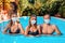 A holiday at sea and protection from viruses. A group of young people pose in a pool with medical masks on their faces. The