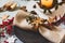 Holiday table setting, black plate with golden napkin holder with star shape, on rustic texture, surrounded by ornaments nandine