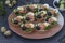 Holiday tartlets with cheese, salmon, black olives, quail eggs and cucumbers on dark background, horizontal orientation