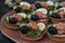 Holiday tartlets with cheese, salmon, black olives, quail eggs and cucumbers on dark background, horizontal orientation