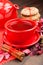 Holiday tea in red cup, cookies, teapot and cinnamon sticks