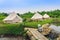 Holiday tents and lounge areas on green lawn place among trees at natural parkland. Camping tent on nature in summer.Travel