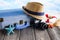 Holiday travel suitcase, photo camera, lifebuoy and shells on wooden table