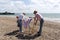 Holidaymakers erecting a deckchair on the beach