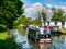 Holidaymakers on a narrowboat cruising on the Leeds to Liverpool Canal in tranquil, rural Lancashire, UK