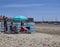 Holidaymakers sheltering from the wind behind a wind Shelter at Beadnell Bay in Northumberland.