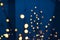 Holidays abstract garland lights unfocused bokeh lamps illumination on dark blue interior background environment