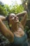 Holidays adventure lifestyle portrait - young beautiful and happy woman taking natural shower from waterfall in the jungle