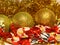 Holidays background close up with gold tinsels, ball decorations, beadwork and christmas candy.