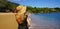 Holidays in Brazil. Panoramic view of female tourist with sundress and straw hat on Ilhabela Island, Sao Sebastiao, Brazil