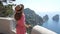 Holidays on Capri Island. Back view of beautiful fashion girl enjoying view of the Faraglioni stacks sea in Capri. Summer vacation