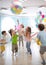 Holidays, childhood and celebration concept - several kids having fun and jumping on birthday party in entertainment