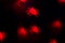 holidays, decoration and party concept - defocused bokeh lights red spiders silhouette on black for halloween background