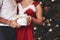 Holidays finally. Beautiful couple celebrating New year in the decorated room with Christmas tree behind